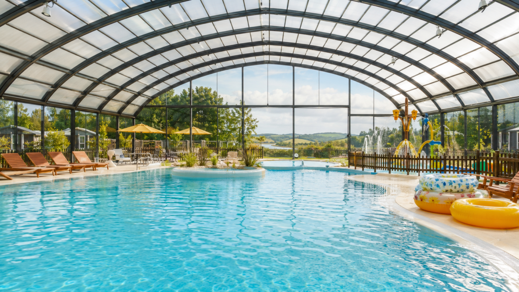 Piscine couverte et chauffée dans un camping familial normand, avec jeux d’eau pour enfants.
